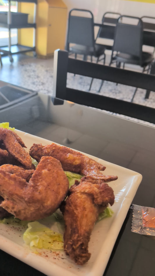 Plate of seasoned chicken wings served with CP’s X ½ Chocolate Habanero Hot Sauce